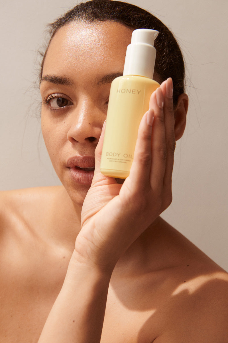 Body Oil from HONEY, bottle hold by woman