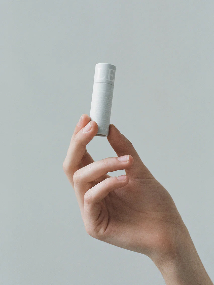 Soothing Lip Balm from LESSE, woman holding the lip balm in her hand
