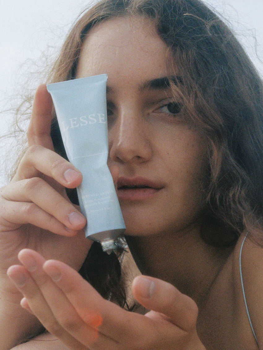 Refining Cleanser from LESSE, woman holding open tube
