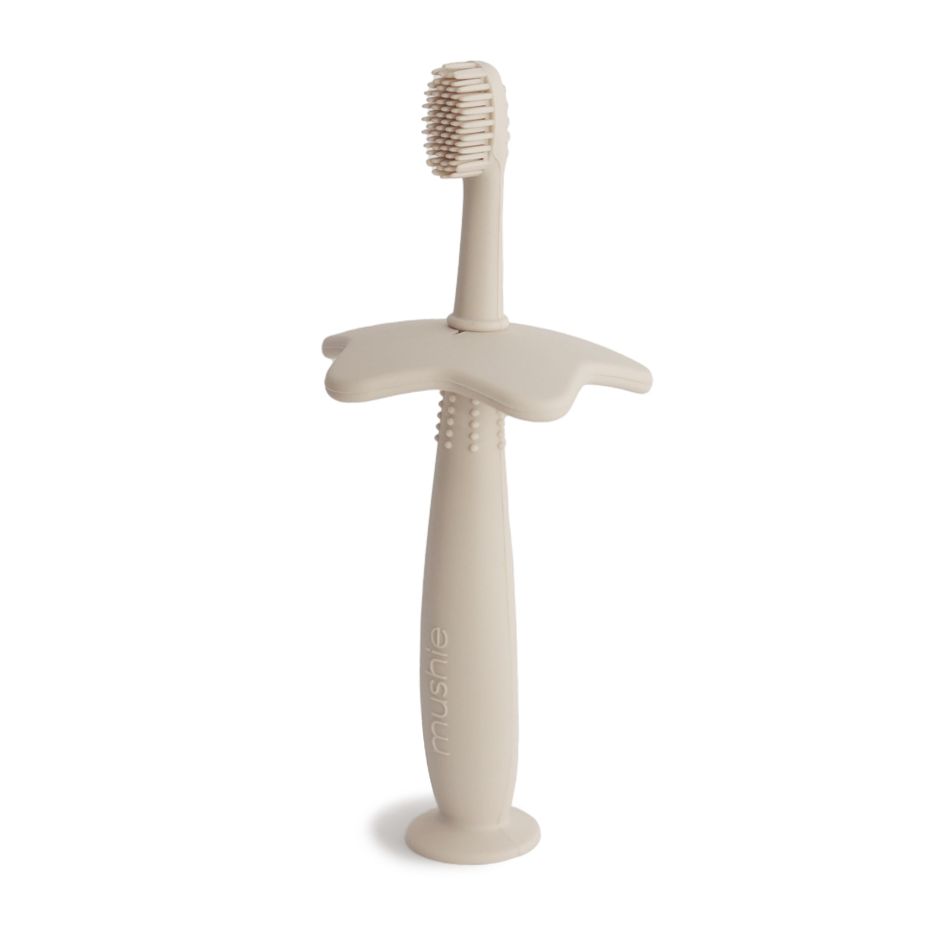 Star training toothbrush from mushie in shifting sand color
