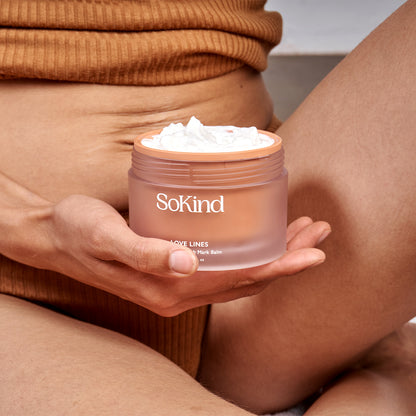 Love Lines from SoKind, a stretch mark balm, open product in a woman's hand